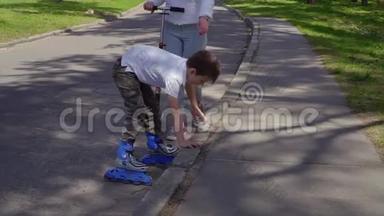 一个穿着溜冰鞋的小男孩在沥青上摔下来后站起来